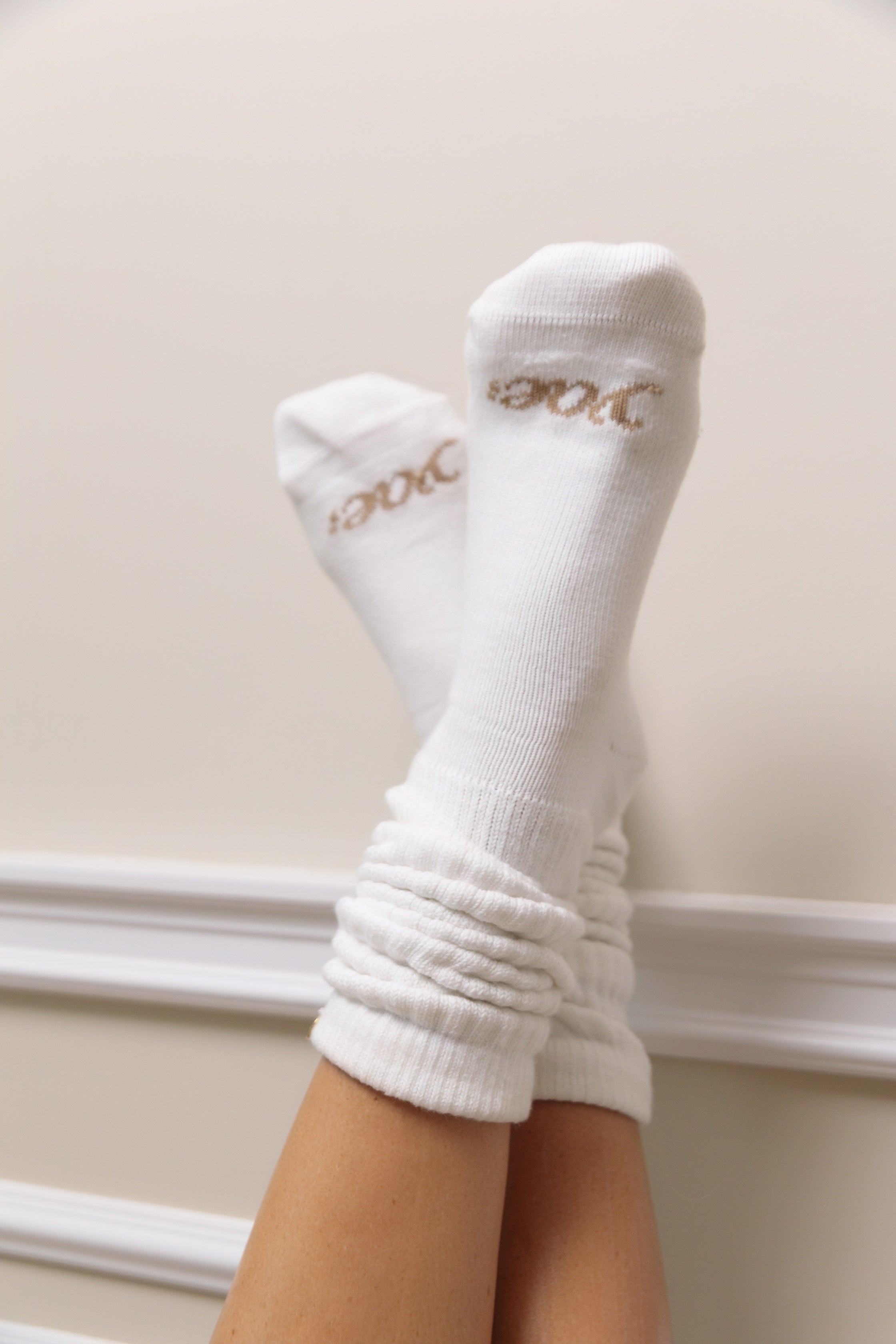 Off White socks with cream text yae logo woven into the toe part on a neutral background