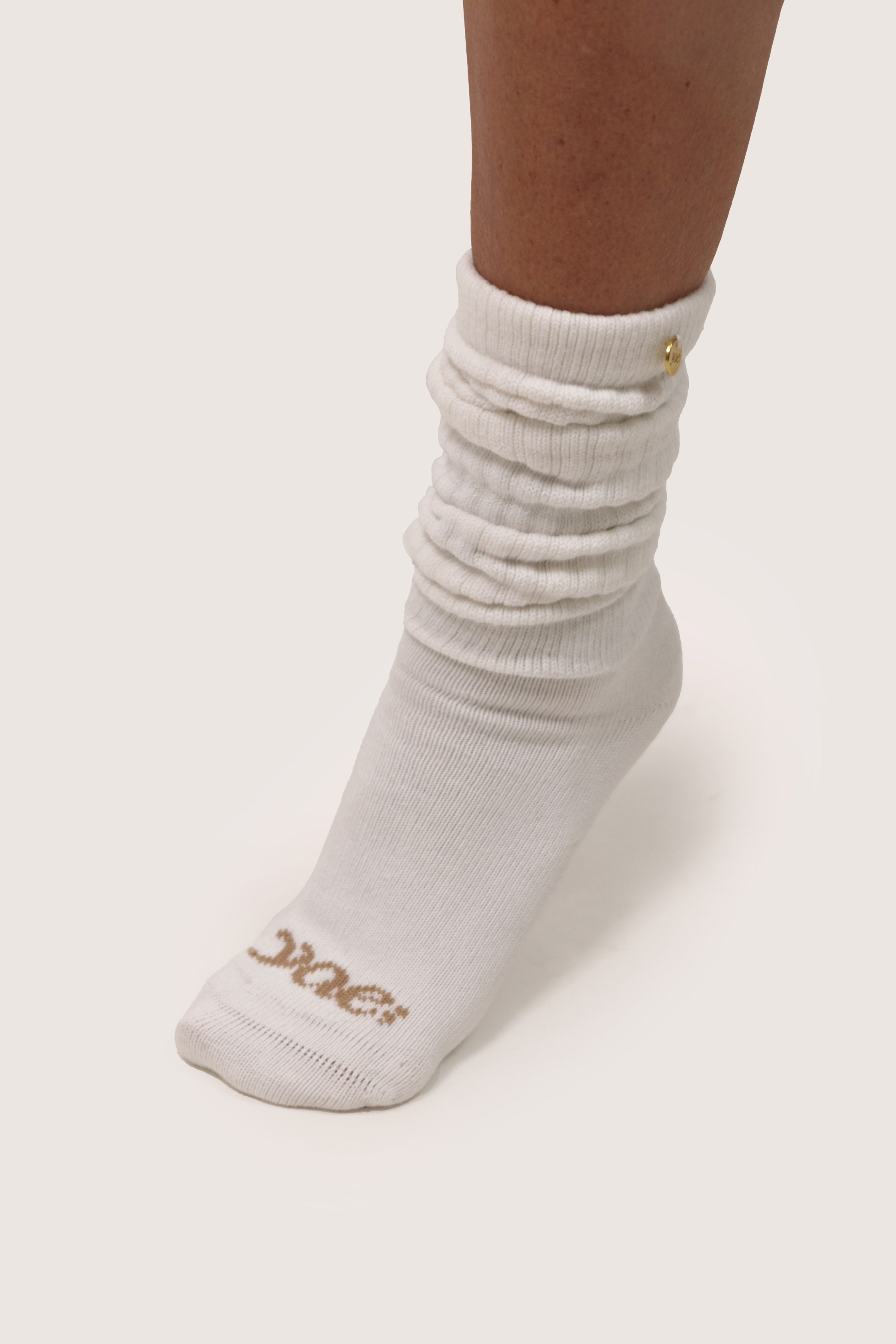 Off white sock with gold logo on a white background