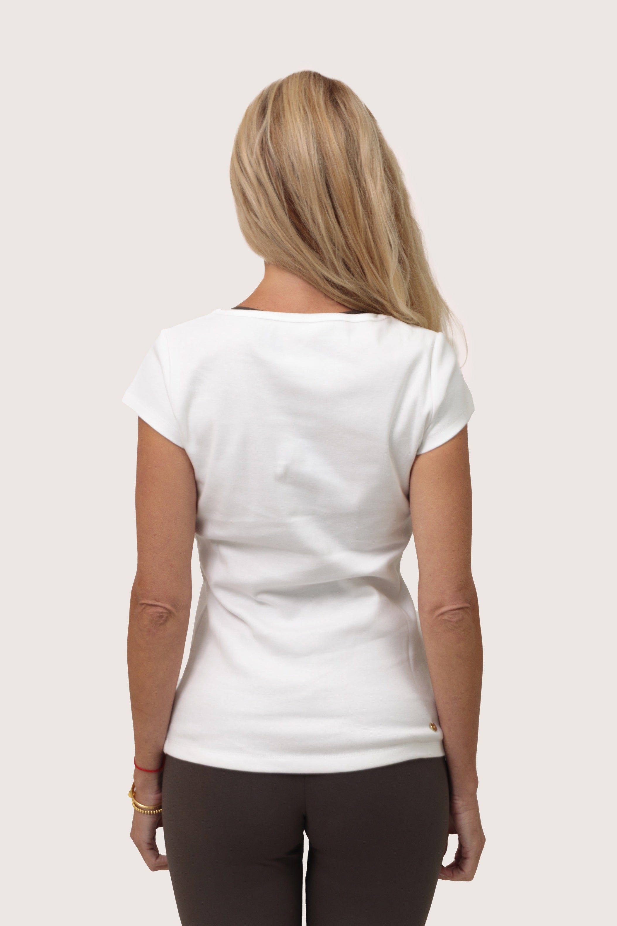 Woman wearing a white t-shirt on a plain background showing the back